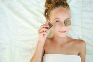 Beautiful girl with tea bags on eyes. Top view. photo
