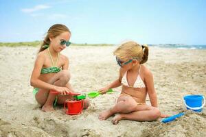 niños jugar con arena en playa. foto