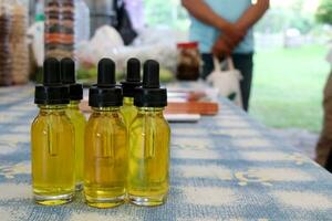 Glass bottles and dropper group on table and light yellow oil bottle. photo