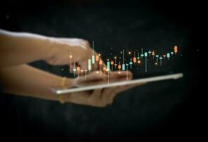Hand of Businesswoman or trader is showing a growing virtual hologram stock on smartphone, planning and strategy, Stock market, Business growth, progress or success concept. invest in trading. photo