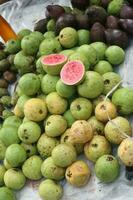 Red guava has the Latin name Psidium guajava on a bamboo plate. photo