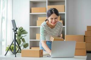 Starting Small business entrepreneur SME freelance, Portrait young woman working at home office, BOX, smartphone, laptop, online, marketing, packaging, delivery, b2b, SME, e-commerce concept. photo