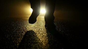 Person walking outside on dark spooky street at night video