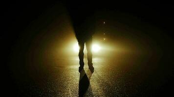 Person walking outside on dark spooky street at night video