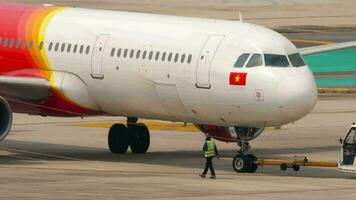 phuket, Thailand februari 25, 2023 - trekker en vliegtuig Aan de vliegveld. Jet vlak van vietjetair taxiën van de terminal Bij phuket luchthaven. passagiersvliegtuig klaar naar nemen uit. toerisme en reizen concept video