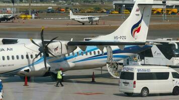 BANGKOK, THAILAND JANUARY 21, 2023 - Plane ATR 72 of Bangkok Airways on the airfield at Suvarnabhumi Airport. Airport staff servicing the aircraft. Airplane pre flight preparation video