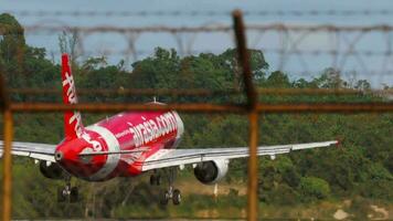 Phuket, Tailandia febbraio 05, 2023 - metraggio di aereo di airasia atterraggio e frenata a Phuket aeroporto. vicino lembi, frenata. aereo di linea in arrivo. asiatico Basso costo compagnia aerea. volo. airbus a320 video