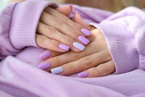 De las mujeres manos con un de moda muy peri manicura . manos con primavera - verano púrpura forma cuadrada clavos. foto