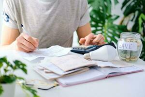 A man counts a bill on a calculator on the table. Payment of utility services. Saving energy and money concept. photo