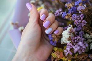 De las mujeres manos con un de moda muy peri manicura en contra el antecedentes de seco flores primavera verano uña diseño foto