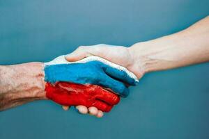 apretón de manos mano pintado con el bandera de Rusia. acuerdo. foto