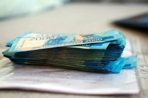 A stack of Russian rubles against the background of documents. Payment of contracts in rubles. Stack of money 2000 rubles photo