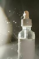 Cosmetic bottles with water splashes on a dark background. photo