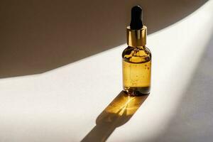 A brown bottle of serum against the beige background.. photo