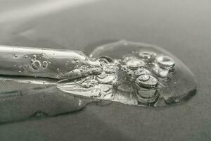 The texture of serum or oil with a pipette on a beige background. photo