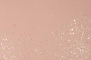 Abstract pink background with sparkles in the shape of stars. photo