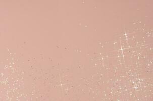 Abstract pink background with sparkles in the shape of stars. photo