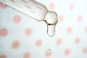 A dripping pipette with a drop of cosmetics gel. photo