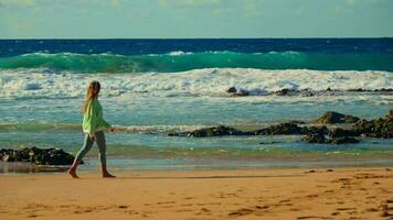 de meisje wandelingen tegen de achtergrond van de golven, de woedend oceaan, de zonsondergang video