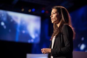 young woman giving a talk at a conference in a bright stage with Generative AI photo