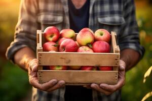 happy young country male farmer holding apple wooden box to carry in orchard with Generative AI photo