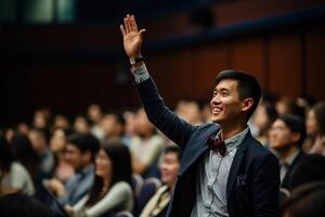 a male student raising hands at a lecture theatre with photo