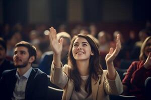 a female student raising hands at a lecture theatre with photo