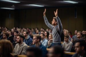 a male student raising hands at a lecture theatre with photo