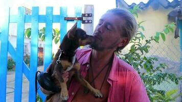 glücklich Mann mit Hund auf seine Arm auf Holbox Insel Mexiko. video