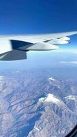 ver desde avión ventana de nevadas montañas en invierno. video