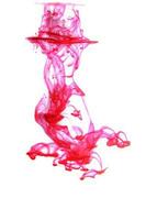 A drop of fuchsia paint in water. photo