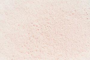 el textura de jabón espuma con burbujas en un rosado antecedentes. foto