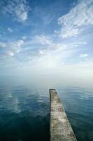 Buna or pier, stretching into the distance between the sky and the sea. photo