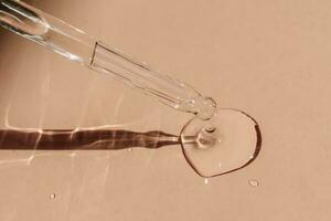 A drop of cosmetic oil falls from the pipette. photo