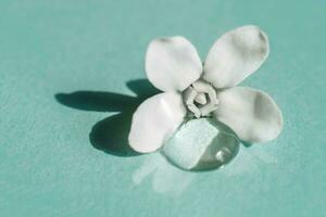 A drop of transparent cosmetic gel with flower on a blue background. photo