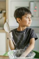 The child cooks in the kitchen. Sifts the flour. photo