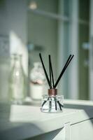 An aromatic reed diffuser stands on a table against a blurry background. photo