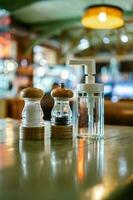 A salt and pepper shaker and an antiseptic stand on the table in a bar or cafe. photo