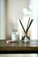 An aromatic reed diffuser stands on a table against a blurry background. photo