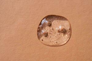 A drop of cosmetic gel on a beige background. photo