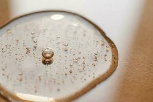 A drop of cosmetic gel on a beige background. photo