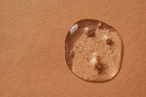 A drop of cosmetic gel on a beige background. photo