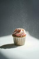 Cupcake on a dark background, which is sprinkled on top. photo