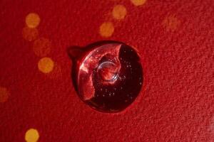 un soltar de suero en un rojo antecedentes con Bokeh. foto