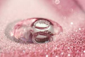 A drop of cosmetic gel on a pink shining background. photo