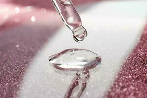 Cosmetic pipette with a pink on dark background. photo