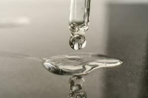 The texture of serum or oil with a pipette on a grey background. photo