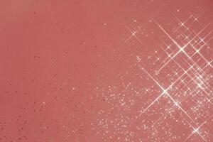 Abstract coral background with sparkles in the shape of stars. photo