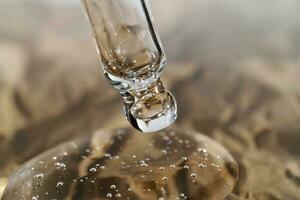 The texture of serum or oil with a pipette on a beige background. photo