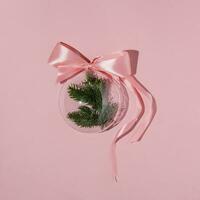 A balloon with a Christmas branch on a pink background. photo